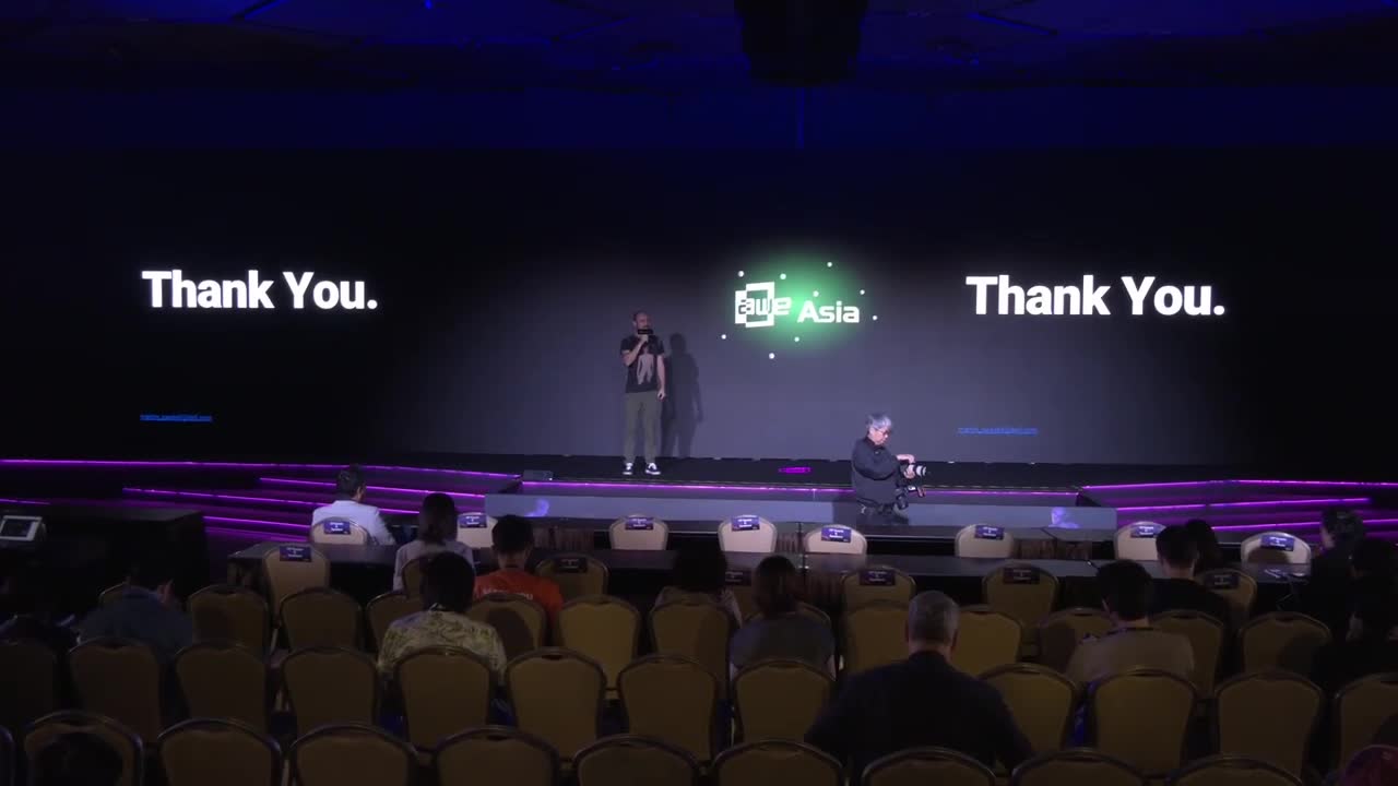 Wide shot of the AWE Asia venue from the audience, stage lit, “Thank You” closing slide on screen