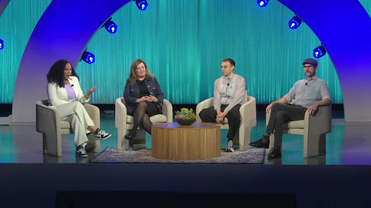 Four panelists in armchairs on the Dell Technologies World 2025 stage under blue arch lighting, Martin far right in a flat cap